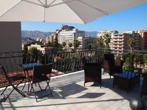 a patio with chairs and an umbrella on a balcony at Alberico Gentili in Palermo