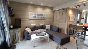 ein Wohnzimmer mit einem Sofa und einem Tisch in der Unterkunft 12 Résidence de la mer in La Couarde-sur-Mer