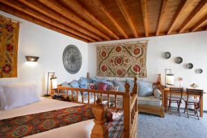 una camera da letto con un letto e un divano di Melenos Art Boutique Hotel a Líndos