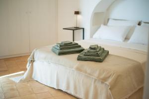 a bed with two towels sitting on top of it at Dammuso Oltremare - Appartamento Lantana in Pantelleria