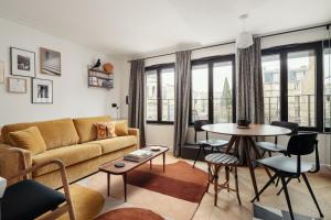 een woonkamer met een bank en een tafel bij My Maison In Paris Invalides in Parijs