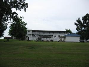 a large white building with a field in front of it at Twin Lakes Inn in Bull Shoals