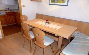 una mesa de madera con 2 sillas y una mesa en Ferienhaus Nr 35, Kategorie Komfort L, behindertenfreundlich, Feriendorf Hochbergle, Allgäu, en Bichel