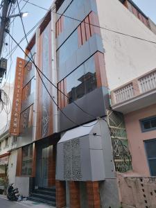 a building with a glass facade on a street at Hotel Vijay laxmi in Haridwār