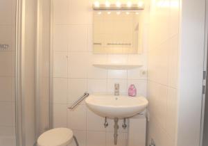 een badkamer met een wastafel, een toilet en een spiegel bij Deichstraße 15 W A 13 in Norddeich