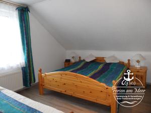 1 dormitorio con cama de madera y ventana en Kutterstr 15 Blunk, en Norddeich