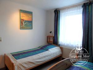 1 dormitorio con 2 camas individuales y ventana en Kutterstr 15 Blunk, en Norddeich