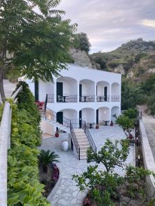 a large white building with stairs and trees at Casa Maria luxury B&B in Ischia