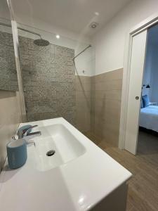 a bathroom with a white sink and a bedroom at Casa Maria luxury B&B in Ischia