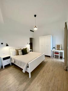una camera bianca con un grande letto bianco e una scrivania di Casa Maria luxury B&B a Ischia