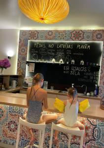 two women sitting on chairs in front of a counter at Citrus SPA Hotel in Jēkabpils