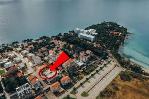 une île au milieu de l'eau avec une flèche rouge dans l'établissement Apartment Eveline, à Petrčane