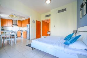 a bedroom with a large bed and a kitchen at Discovery Gardens Studio near Ibn Battuta Mall & Metro - SAN in Dubai