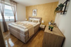 a bedroom with a large bed and a wooden floor at Apartment Eveline in Petrcane