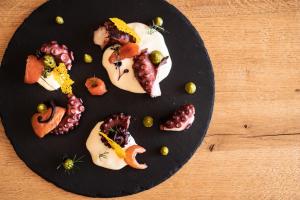um prato preto de comida numa mesa de madeira em Corona Dolomites Hotel em Andalo