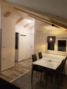 jadalnia z białym stołem i krzesłami w obiekcie Apartments and Rooms Ivana w Krku
