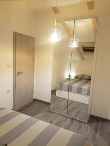 sypialnia z lustrem i łóżkiem w obiekcie Apartments and Rooms Ivana w Krku