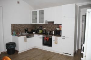 a kitchen with white cabinets and a stove top oven at Stadtpark Rooms Vienna in Vienna
