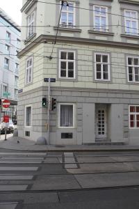 a building on the corner of a street with a traffic light at Stadtpark Rooms Vienna in Vienna