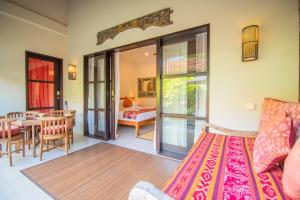 a living room with a couch and a dining room at Kembali Lagi Guest House in Sanur