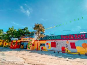 Tây Ninh的住宿－Khách sạn Vườn Cau & Khu vui chơi giải trí SaLa，街道旁有食物和啤酒标志的建筑物
