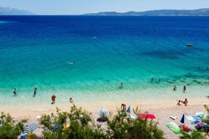a group of people in the water at a beach at Apartments & Restaurant Galeb in Marusici 