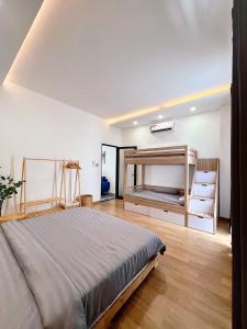 1 dormitorio con 1 cama grande y suelo de madera en Bông Villa Hotel & Apartment, en Kon Tum