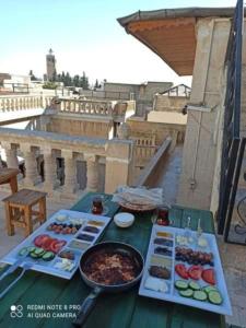 een tafel met borden eten op een balkon bij JOSELİN HOTEL in Sanlıurfa