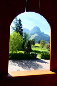 uma janela arqueada com vista para uma montanha em Casa El Tobià em Pozza di Fassa