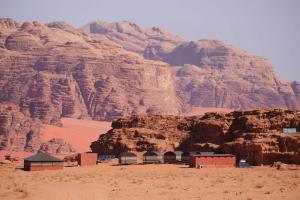 a building in the desert next to a mountain at Wadi rum Local guide camp in Wadi Rum