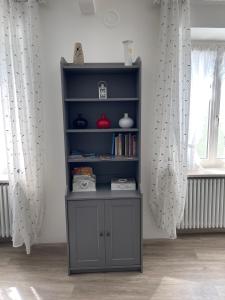 a book shelf in a living room with curtains at Casa Vacanza Revolta in Trento