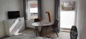 uma sala de estar com uma mesa e cadeiras e uma televisão em Ferienwohnung im Bauernhaus em Gallin