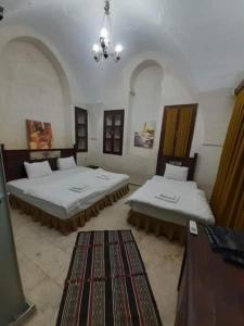 a bedroom with two beds and a chandelier at JOSELİN HOTEL in Urfa