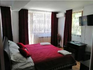 a bedroom with a large bed with a red blanket at CASA GABI'S in Orşova