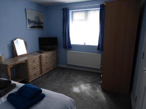 a bedroom with a bed and a window and a dresser at self-contained private apartment in Barnet