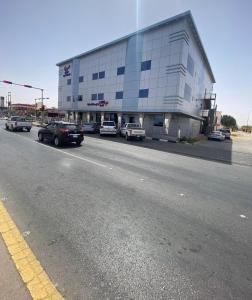 a building with cars parked on the side of a road at شقق ديار الأحبة للوحدات السكنية شقق مخدومة اقتصادي in Sakakah