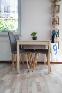 una mesa de madera y sillas en una habitación con suelo en Keba, en Władysławowo