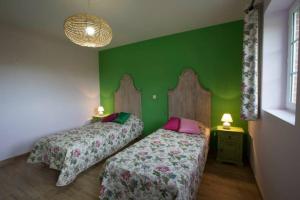 2 camas en una habitación con una pared verde en Le parc de Crécy, en Crécy-Couvé
