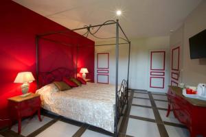 Schlafzimmer mit einem großen Bett mit roten Wänden in der Unterkunft Le parc de Crécy in Crécy-Couvé