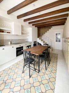 a kitchen with a wooden table and chairs on a tiled floor at Terra i Mar in Cabanes