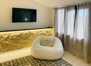 una silla con bolsa de frijoles blancos en una habitación con TV en Terra i Mar en Cabanes