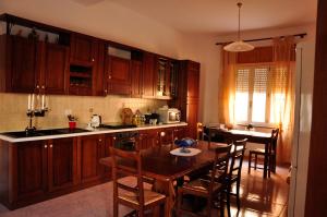 a kitchen with wooden cabinets and a table with chairs at B&B L'Asfodelo in Fluminimaggiore