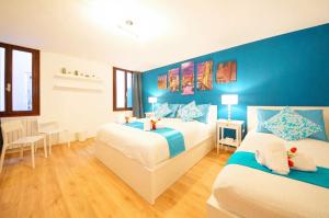 um quarto com 2 camas e uma parede azul em Calle dei Fabbri Apartment Marble em Veneza