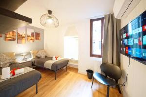 a living room with a couch and a tv at Calle dei Fabbri Apartment Marble in Venice