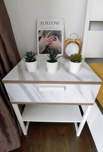 una mesa blanca con tres macetas. en C1108 Almas Suites Muji Studio100mbpsNetflix STAY, en Nusajaya