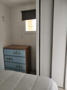 um quarto com uma cama, uma cómoda e um espelho em Charmant T2 en rez de chaussée em Balaruc-les-Bains