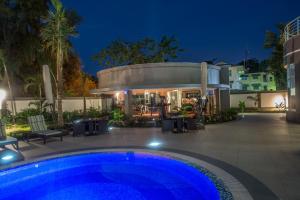 a swimming pool in front of a building at night at The George Hotel in Lagos