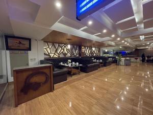 a restaurant with couches and tables in a room at Grand Mongolia Hotel in Rawalpindi