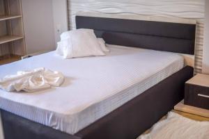 a bed with white sheets and pillows on it at Apartament Mamaia Nord VS14 in Mamaia