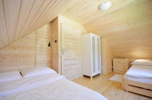 sypialnia z 2 łóżkami w drewnianym pokoju w obiekcie DOMKI Z BALA w Pobierowie